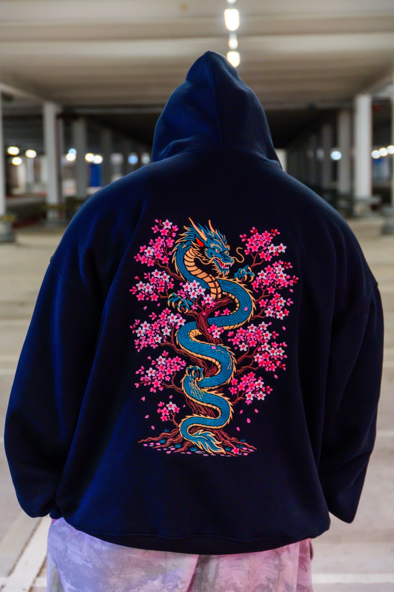 Sakura Dragon back print - model wearing black heavyweight hoodie with emerald dragon and sakura embroidery